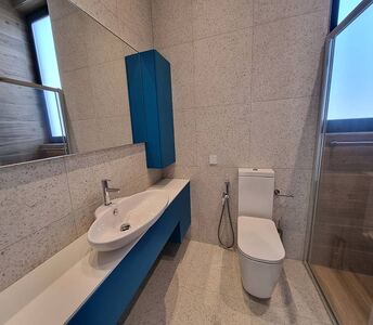 En suite bathroom of the master bedroom with wall tiles up to the ceiling, shower glass, bidet, and a large mirror