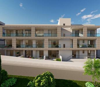 Modern three-storey apartment building in the city center of Paphos with glass railings and landscaped surroundings